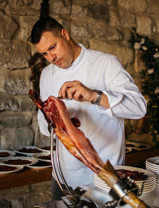 Cortador de jamón trabajando junto a la mesa.